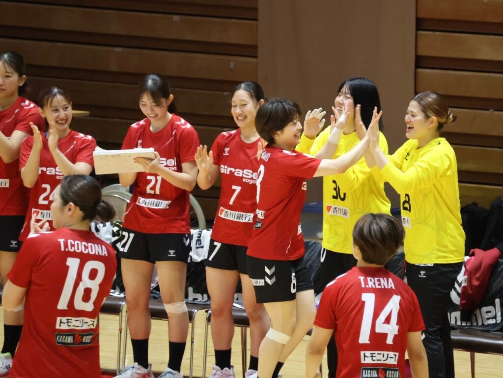 ベンチでハイタッチをする選手たち